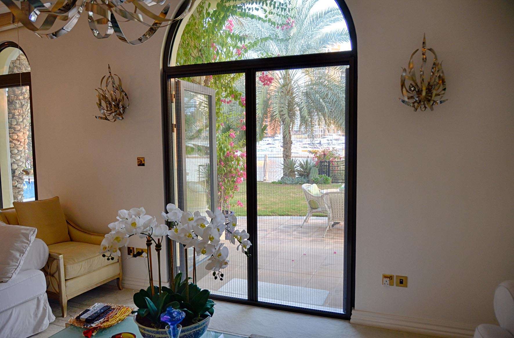 Wide double retractable fly screen on Palm Jumeirah luxury villa pool-facing patio — black frame grey mesh Dubai