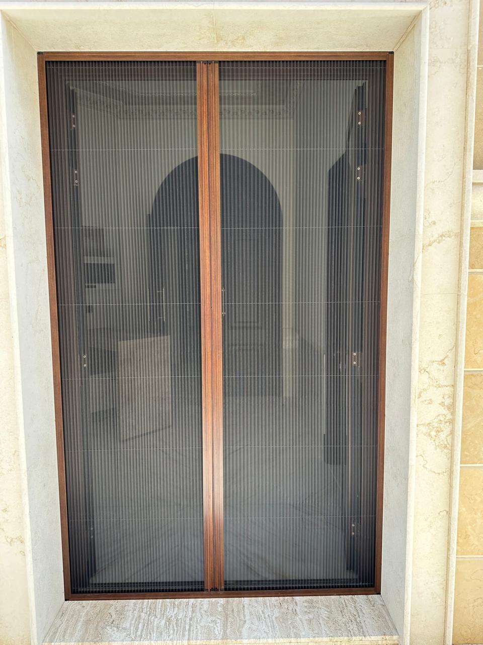 Retractable fly screen on The Lakes villa window — white frame black mesh Dubai