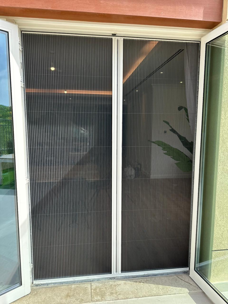 Two-way retractable fly screen on Meydan villa garden patio door — white frame grey mesh Dubai