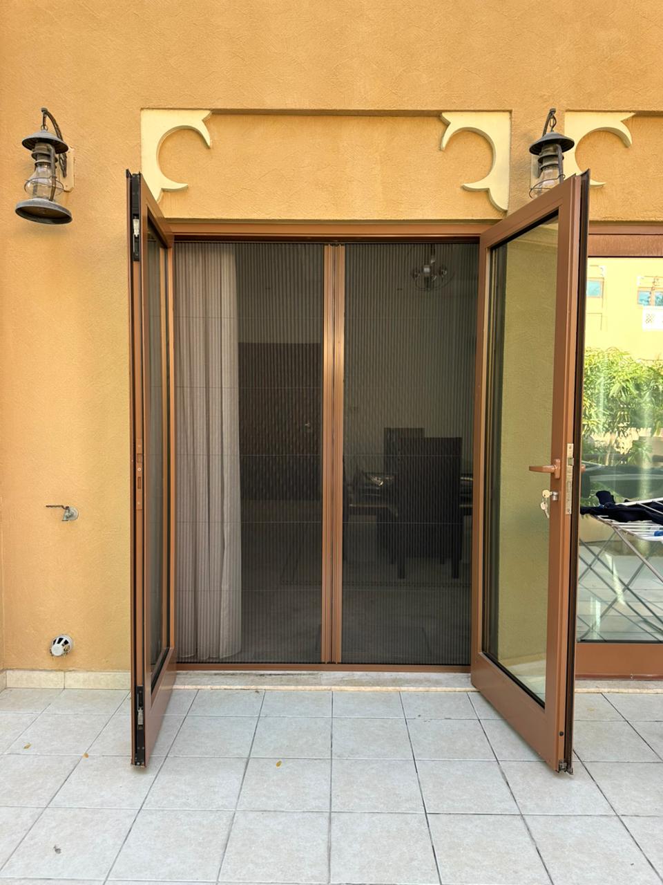 Single retractable fly screen on Meydan villa entrance door — bronze frame black mesh Dubai