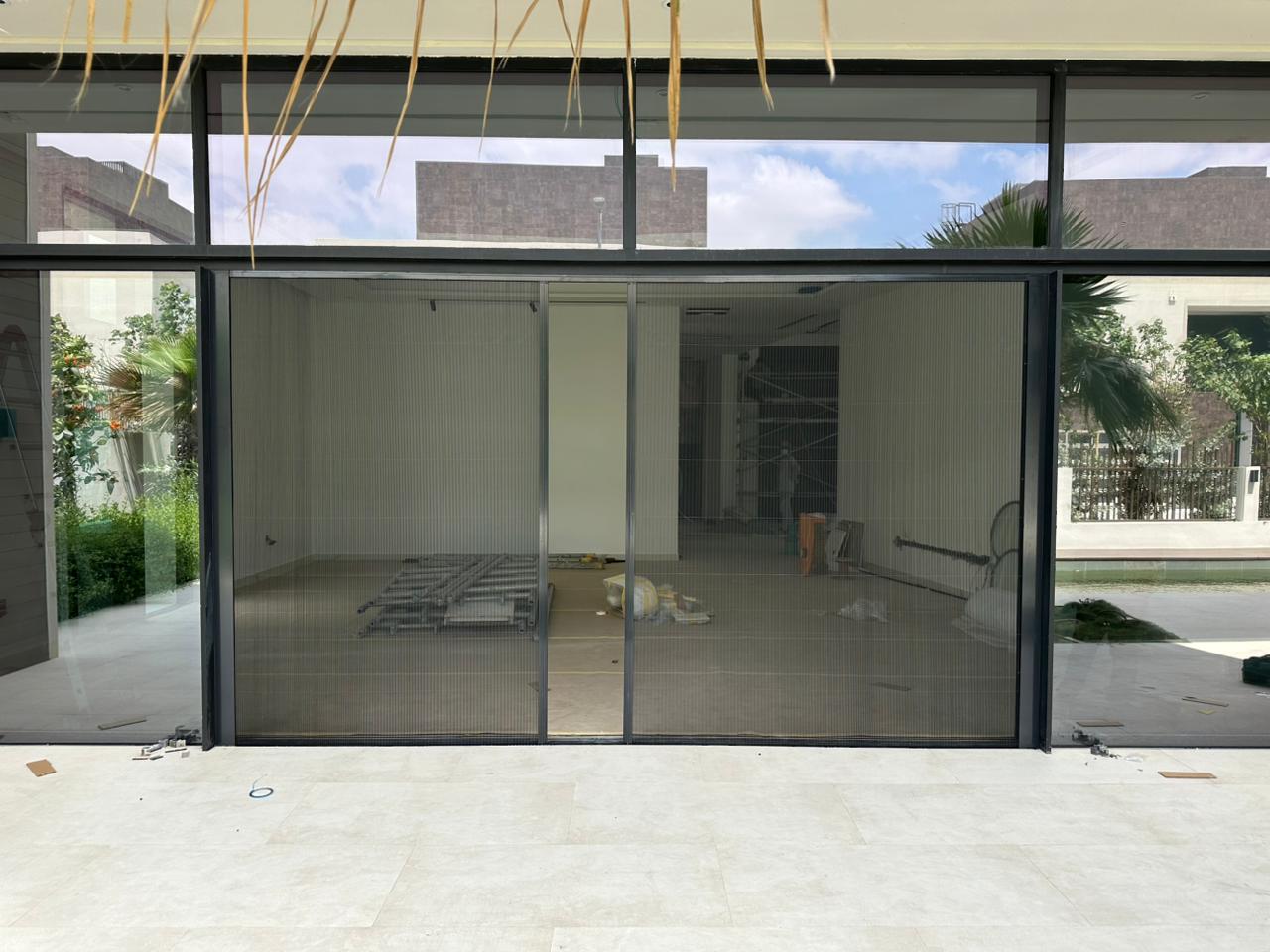Retractable pleated fly screen on Dubai Hills Estate villa garden door, white aluminium frame black mesh, golf course view Dubai