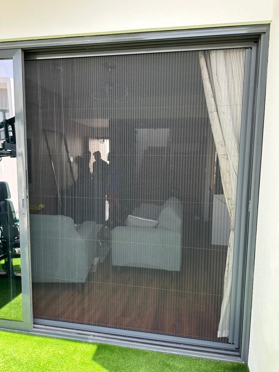 Single retractable fly screen on Business Bay apartment balcony — dark frame black mesh Dream Fly Screen Dubai