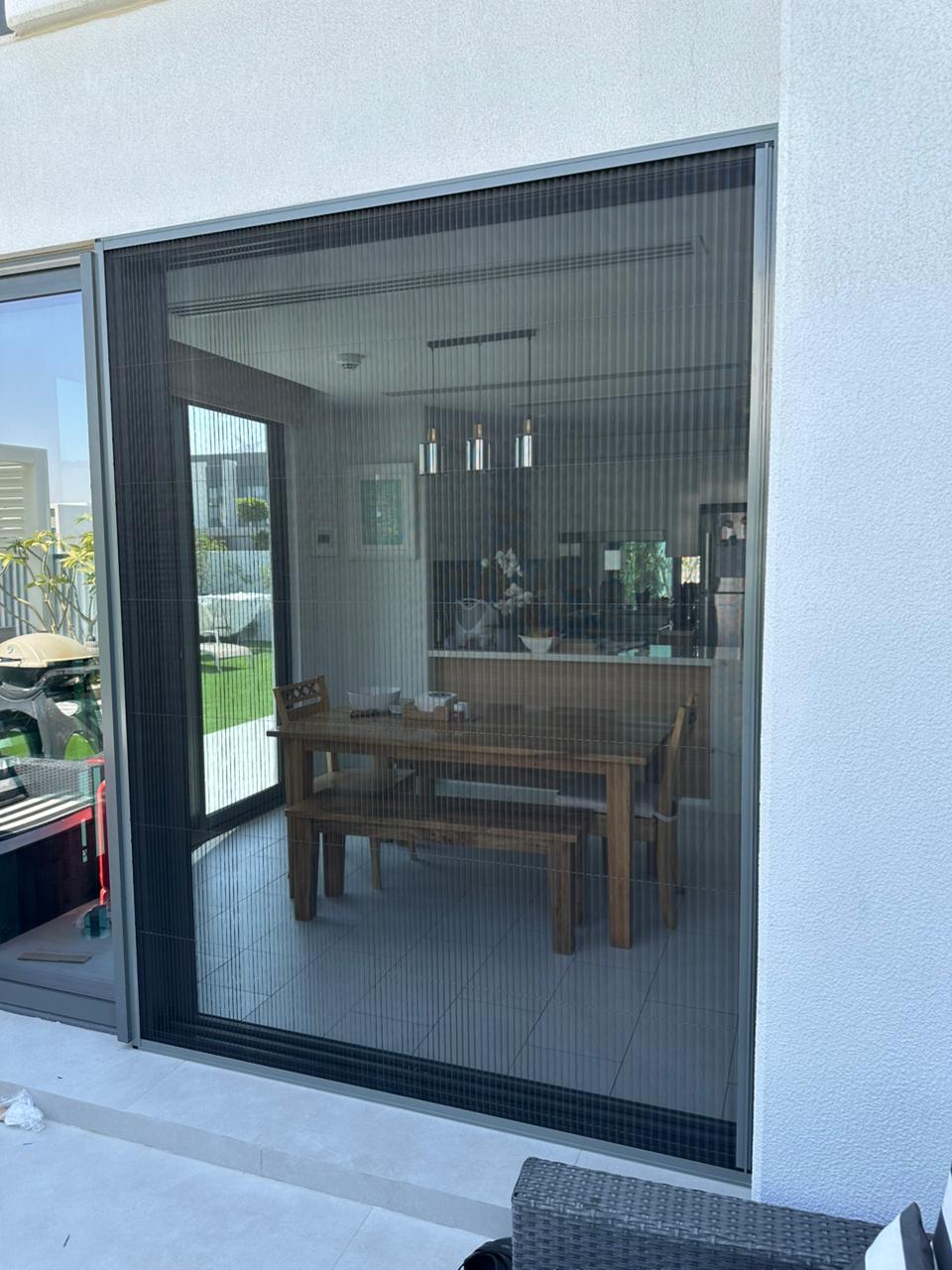 Custom fly screen on Downtown Dubai luxury apartment window overlooking Dubai Fountain, dark grey mesh white frame, UAE