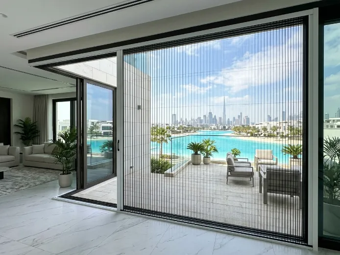 Retractable pleated fly screen on District One mega-villa garden door, white aluminium frame black mesh, Crystal Lagoon view Dubai