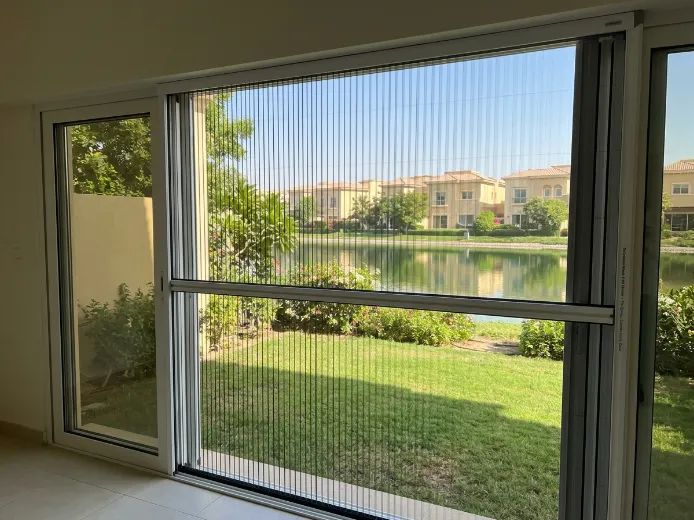 Retractable pleated fly screen on The Springs townhouse garden door, white aluminium frame black mesh, lakeside Emirates Living Dubai