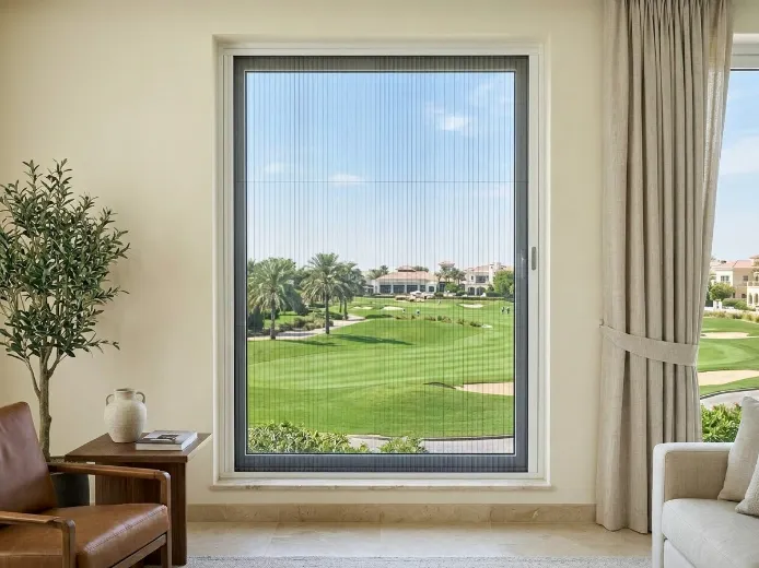 Single fly screen for window in Emirates Hills mansion with white aluminum frame and dark grey pleated mesh preserving golf course views